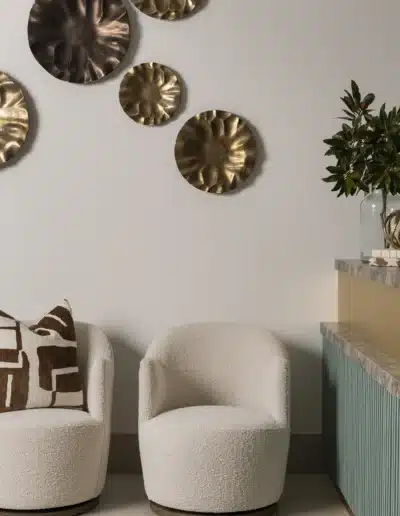 Cream boucle swivel chairs and decorative metallic wall plates in Elite Dermatology lobby. Cream boucle swivel chairs and decorative metallic wall plates in Elite Dermatology lobby.