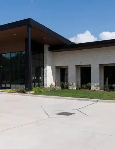 Side angle of Elite Dermatology Kingwood building showcasing white stone wall facade. Side angle of Elite Dermatology Kingwood building showcasing white stone wall facade.