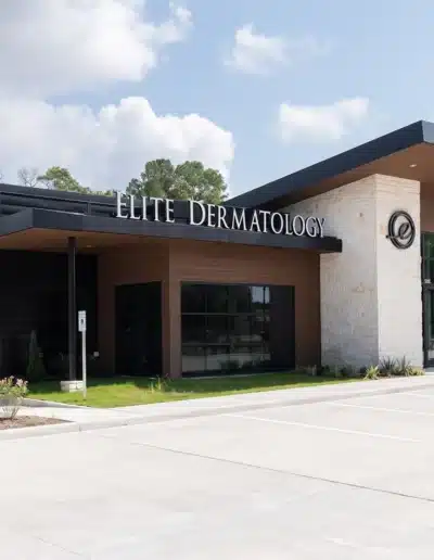 Exterior view of Elite Dermatology Kingwood facility under a blue sky with parking lot. Exterior view of Elite Dermatology Kingwood facility under a blue sky with parking lot.