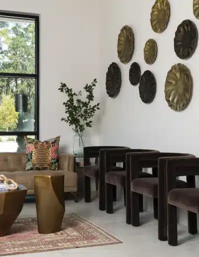 Velvet armchairs, brass side table, and textured metallic wall sculptures in Elite Dermatology lobby. Velvet armchairs, brass side table, and textured metallic wall sculptures in Elite Dermatology lobby.