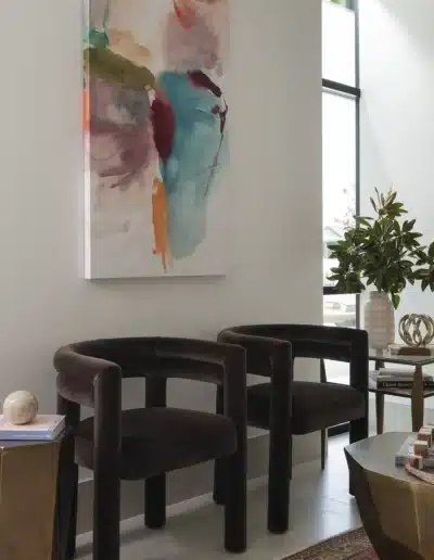 Dark brown velvet armchairs next to large window and abstract canvas art in a medical spa lobby. Dark brown velvet armchairs next to large window and abstract canvas art in a medical spa lobby.
